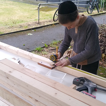 boy measuring wood for cutting